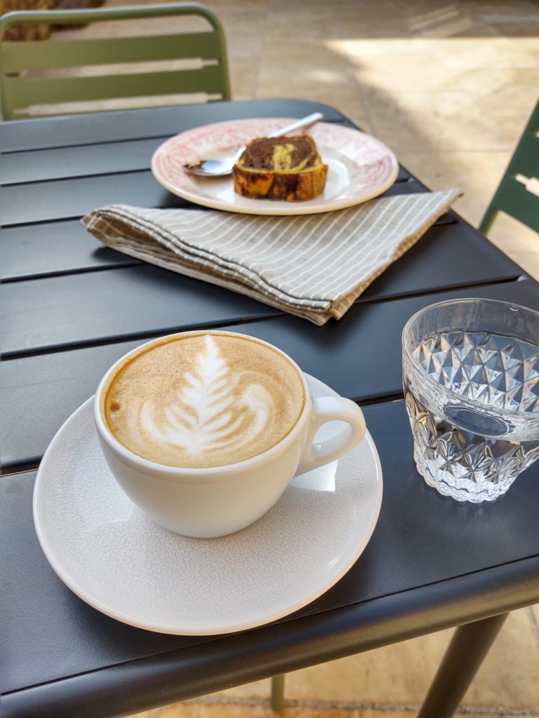 Cappuccino ou latte en terrasse, accompagné d'une part de gâteau marbré